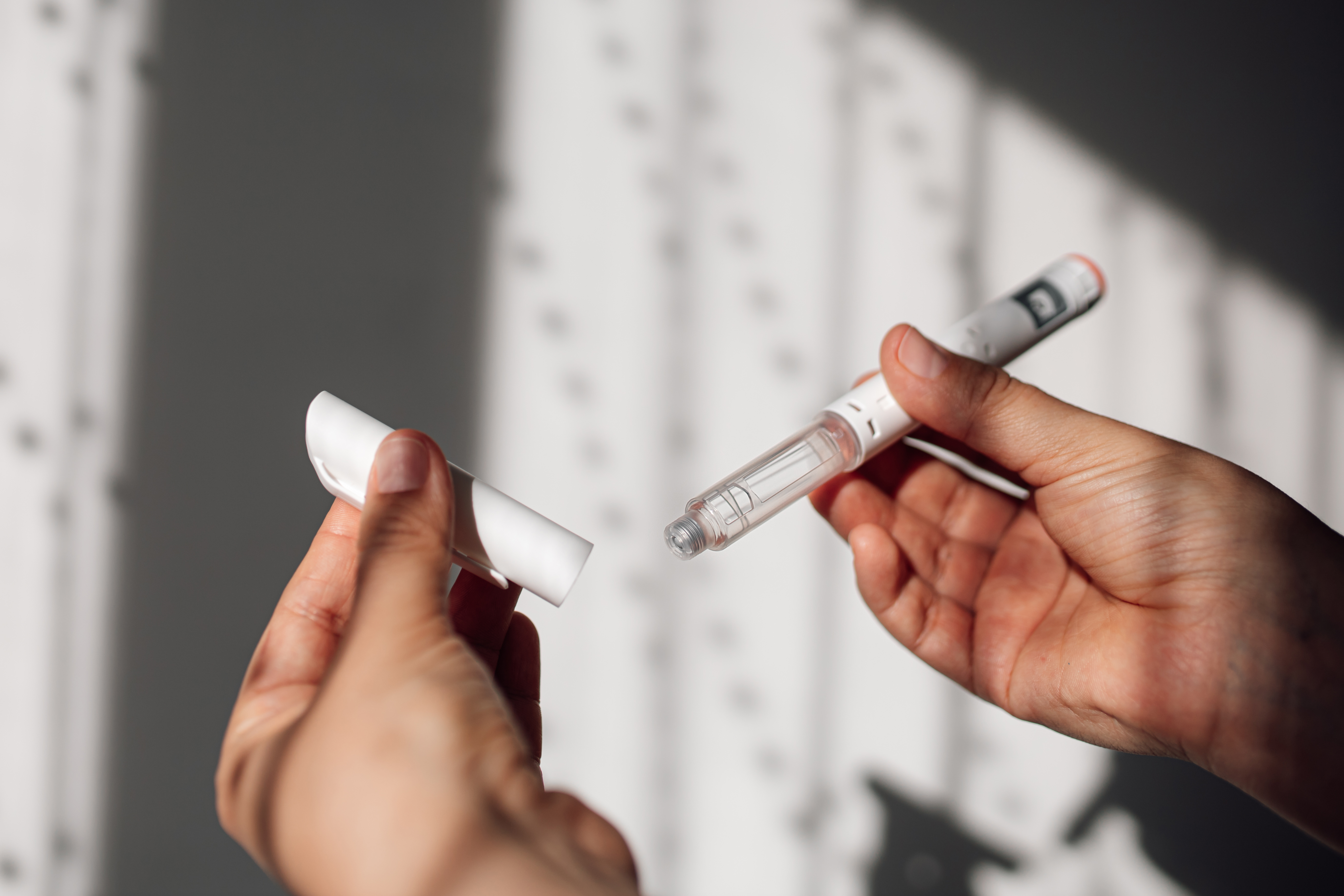 A person holds an injectable weight loss drug.