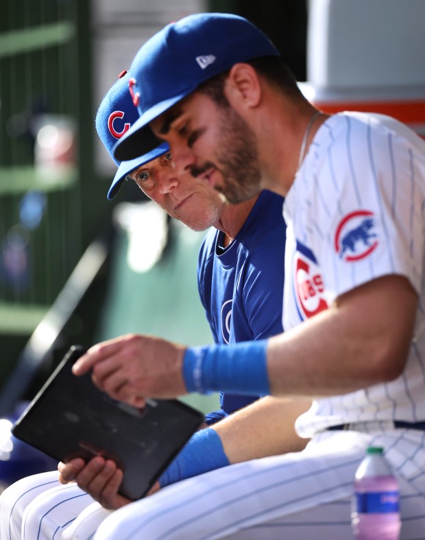 Chicago Cubs assistant hitting coach John Mallee studies data on a tablet with designated hitter Mike Tauchman after an at-bat by Tauchman against the Pittsburgh Pirates at Wrigley Field in Chicago on May 16, 2024. (Chris Sweda/Chicago Tribune)