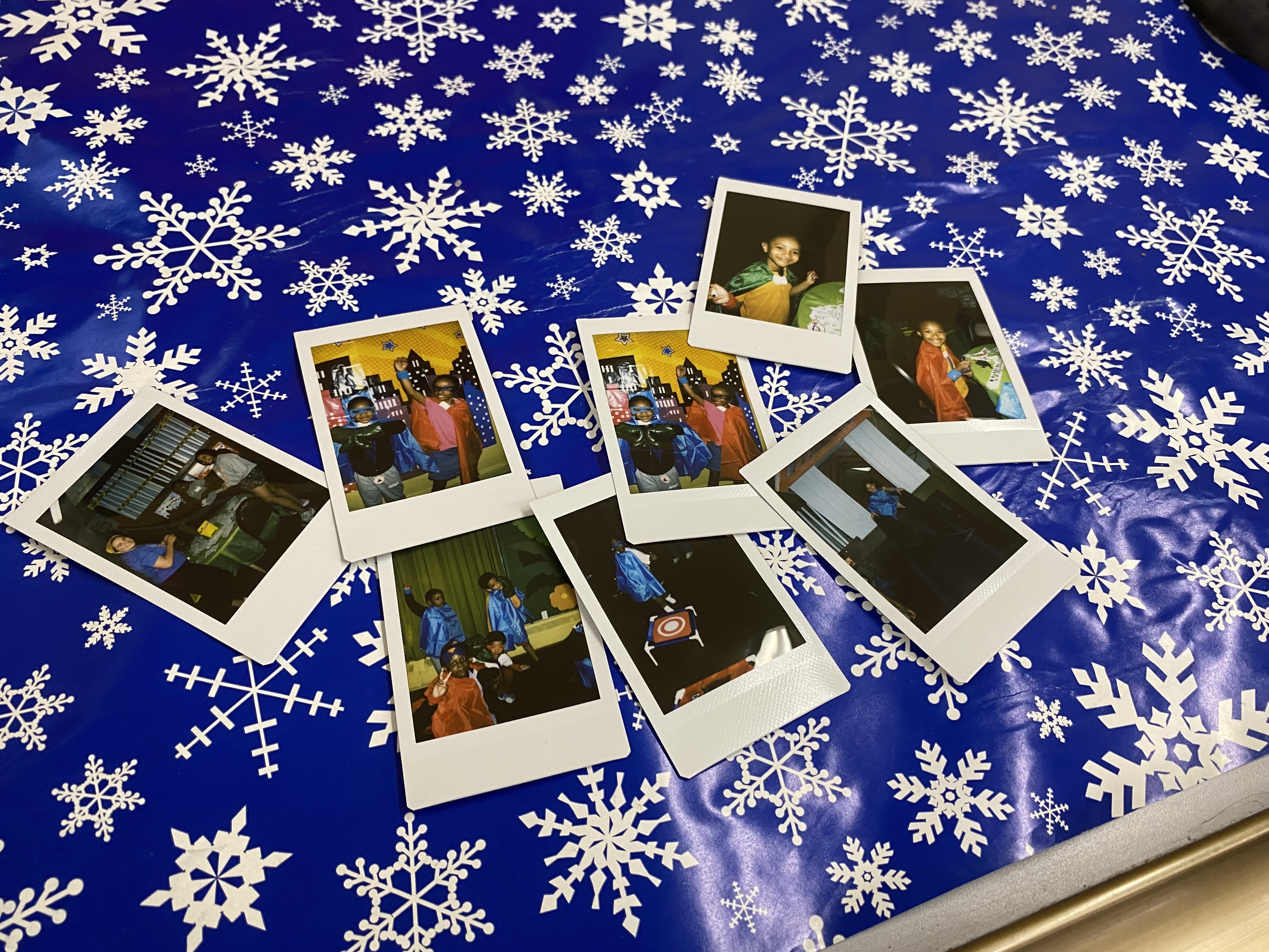 Polaroid pictures of children in costumes are scattered around a table.