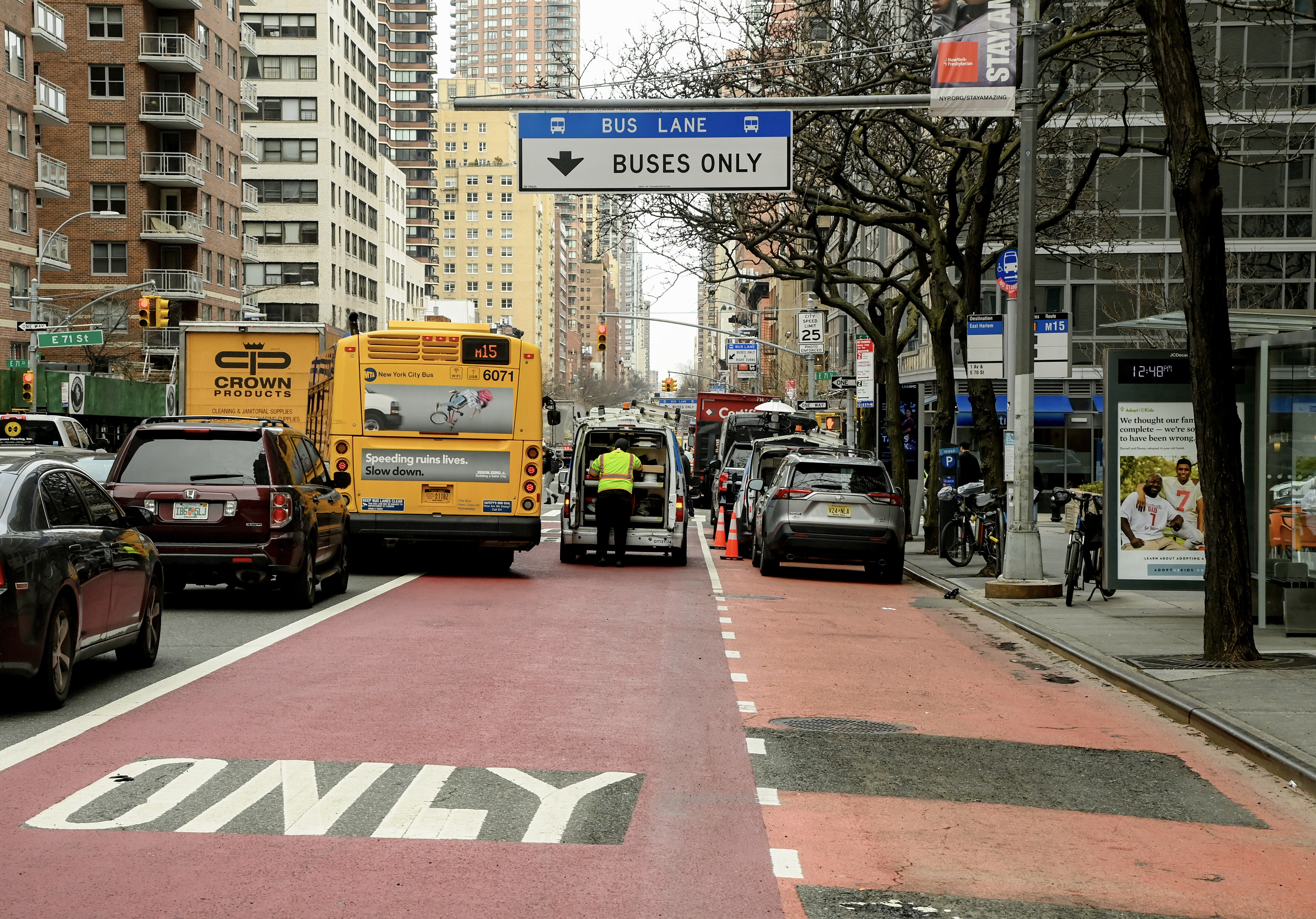 A bus moving around a double parked car in traffic.