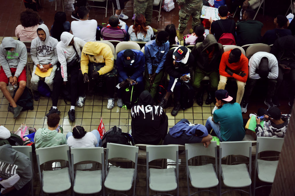 Newly arrived asylum seekers wait in a holding area at the Port Authority bus terminal in Manhattan before being sent off to area shelters and hotels on May 15, 2023.