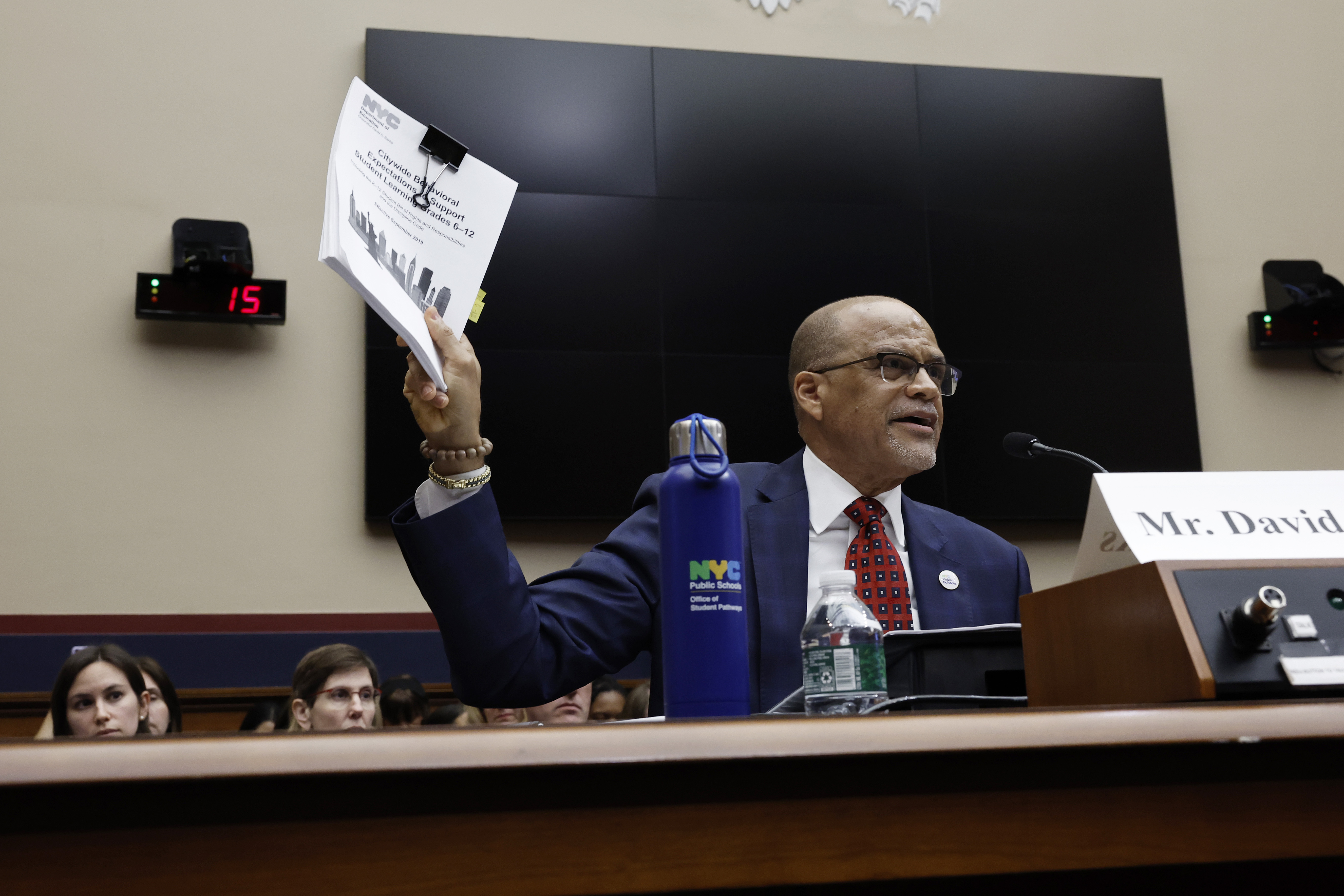 Schools Chancellor David Banks holds a stack of papers while testifying before Congress.