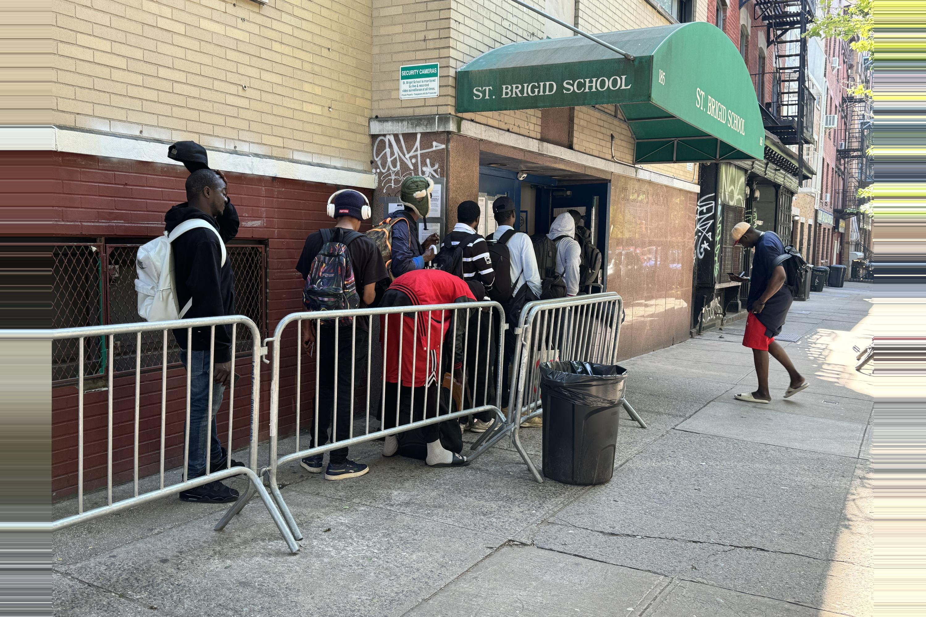 Migrants waited in line outside the city's reticketing center in the East Village on Wednesday morning to reapply for shelter, after their 30- and 60-day stays came to an end. The size of the line fluctuated throughout the morning.