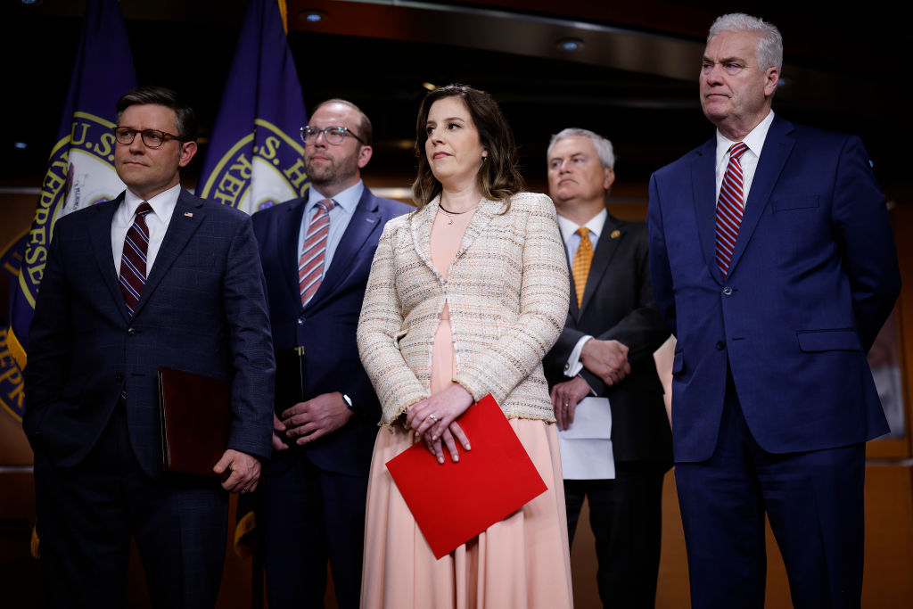 Rep. Elise Stefnik in the center holding a red folder is flanked by House Speaker Mike Johnson and other high ranking Republican congressmembers.