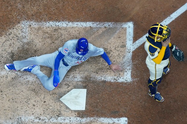 The Cubs' Luis Vazquez scores past Brewers catcher William Contreras during the 10th inning Tuesday, May 28, 2024, in Milwaukee. (AP Photo/Morry Gash)