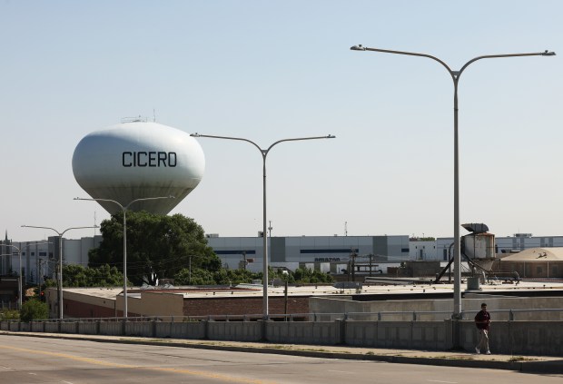 A person walks on the South Laramie Avenue overpass that has a view of the Cicero water tower on May 15, 2024. (John J. Kim/Chicago Tribune)