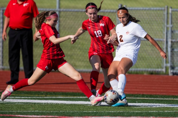 Homewood-Flossmoor's Isla Thompson, left, Homewood-Flossmoor's Ava Loudon (18) try to get the ball away from Lincoln-Way West's Ava Peterson (2) during the Class 3A Homewood-Flossmoor Regional championship game in Flossmoor on Friday, May 17, 2024. (Vincent D. Johnson/for the Daily Southtown)