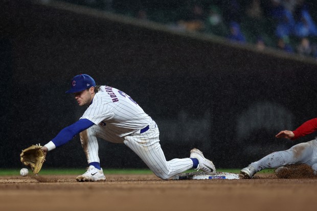 Chicago Cubs second baseman Nico Hoerner (2) is unable to make a catch on a wide throw from Christopher Morel in the fourth inning of a game against the Cincinnati Reds at Wrigley Field in Chicago on June 1, 2024. (Chris Sweda/Chicago Tribune)