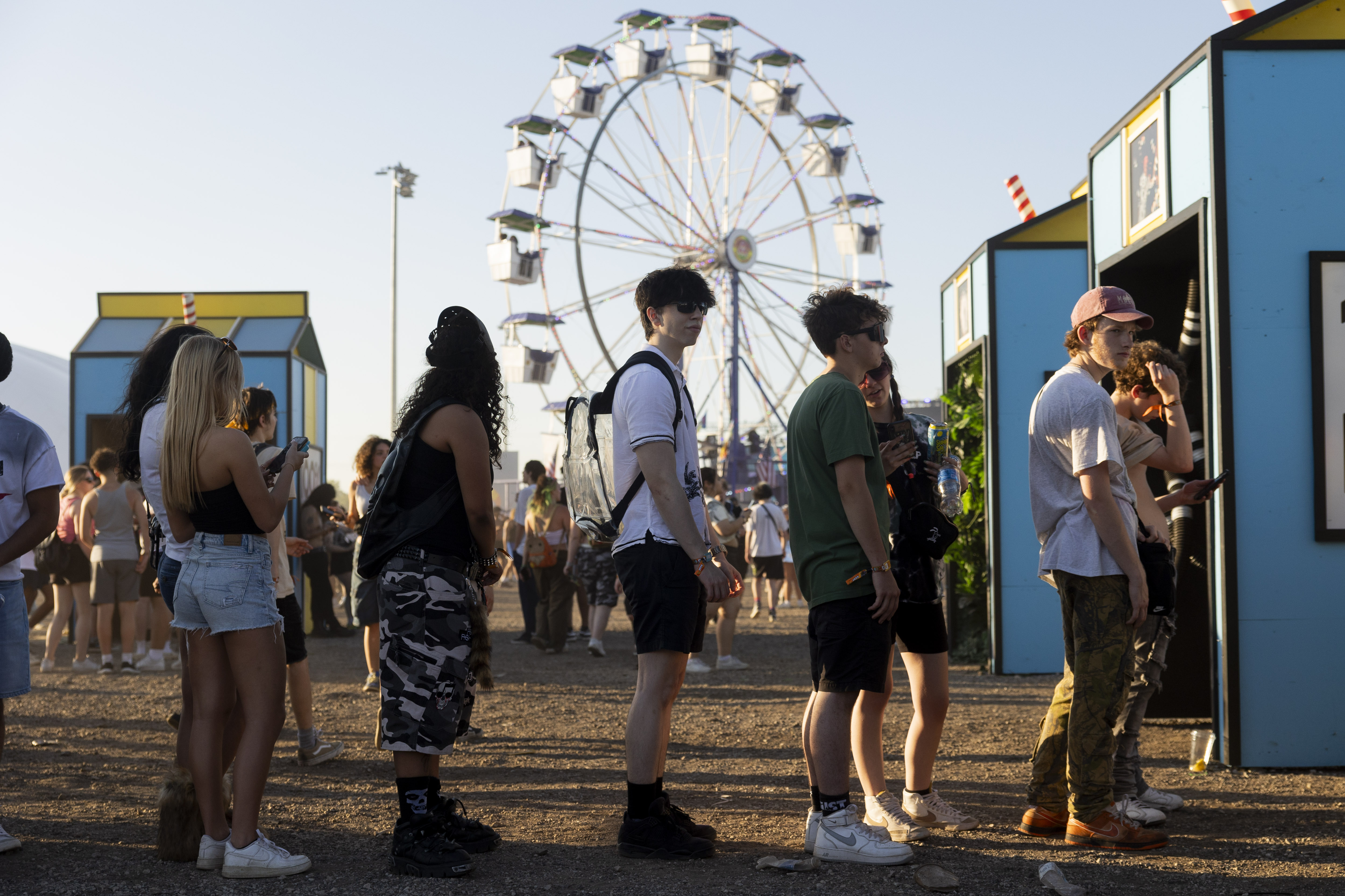 Festival goers wait in line to take photos in a...