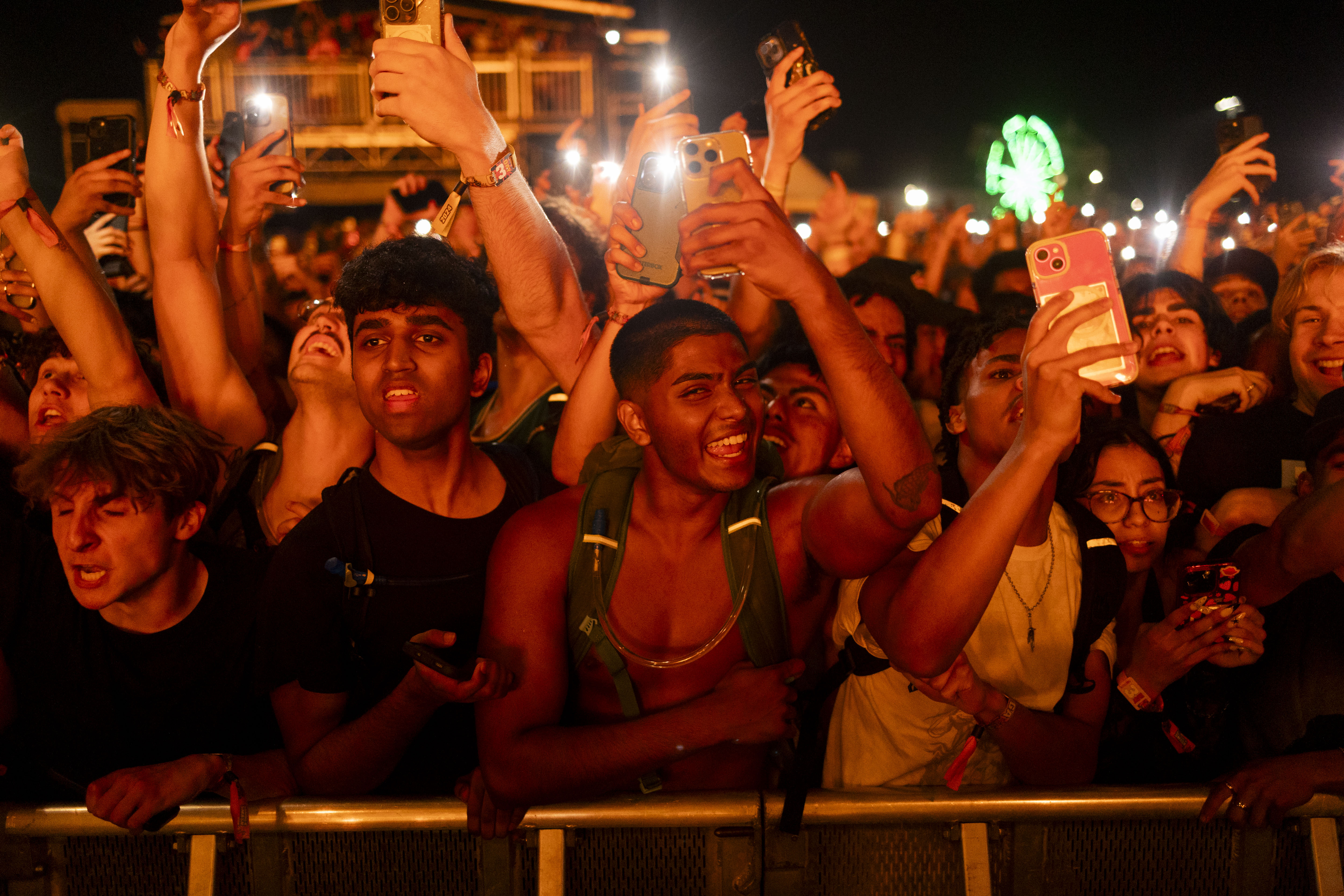 Festival goers cheer as Travis Scott and other members of...