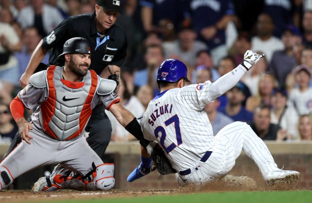 Chicago Cubs designated hitter Seiya Suzuki (27) is tagged out at home plate by San Francisco Giants catcher Curt Casali in the 8th inning of a game at Wrigley Field in Chicago on June 18, 2024. (Chris Sweda/Chicago Tribune)