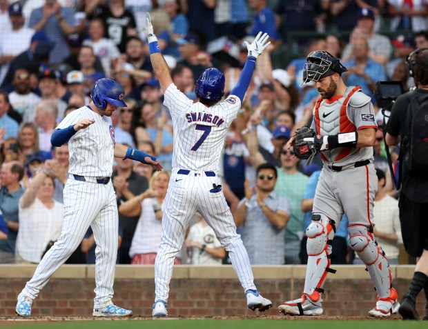 Chicago Cubs shortstop Dansby Swanson (7) is congratulated by teammate Ian Happ after Swanson hit a 2-run home run in the second inning of a game against the San Francisco Giants at Wrigley Field in Chicago on June 18, 2024. (Chris Sweda/Chicago Tribune)