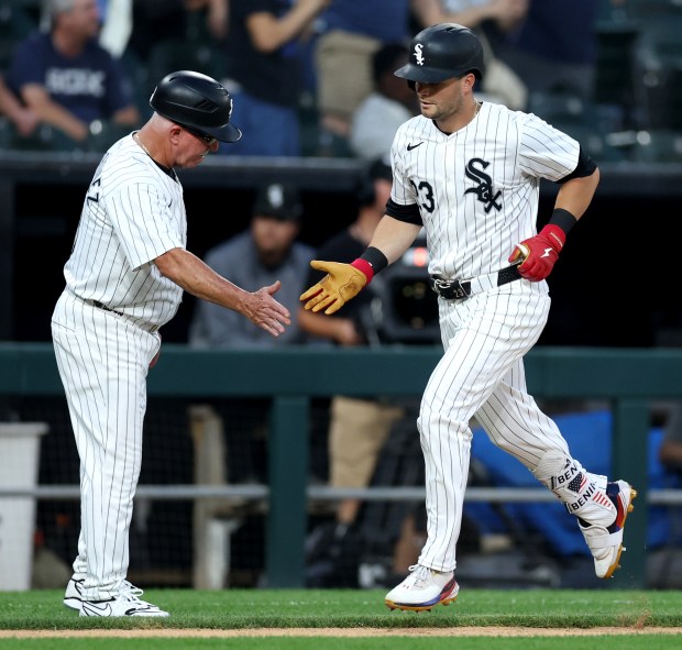 Chicago White Sox left fielder Andrew Benintendi (23) is congratulated by third base coach Eddie Rodriguez as Benintendi rounds the bases after hitting a solo home run in the fourth inning of a game against the Houston Astros at Guaranteed Rate Field in Chicago on June 19, 2024. (Chris Sweda/Chicago Tribune)