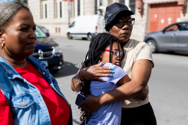 Ethiopia Jackson, right, and Samiram Dyson, 11, both residents of the Oakley Square apartment complex, hug on June 18, 2024, after the fatal shooting of 7-year-old Jaimani Amir Rivera. (Vincent Alban/Chicago Tribune)