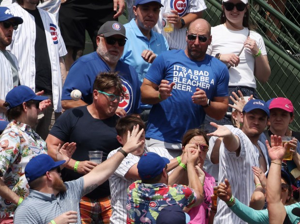 Fans reach for a home run ball hit by Mets catcher Francisco Alvarez in the fifth inning against the Cubs at Wrigley Field on June 22, 2024, in Chicago. (John J. Kim/Chicago Tribune)