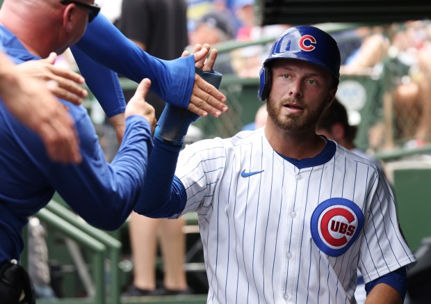 Cubs first baseman Michael Busch is congratulated after scoring off a single by designated hitter Seiya Suzuki in the first inning against the Mets at Wrigley Field on June 22, 2024, in Chicago. (John J. Kim/Chicago Tribune)