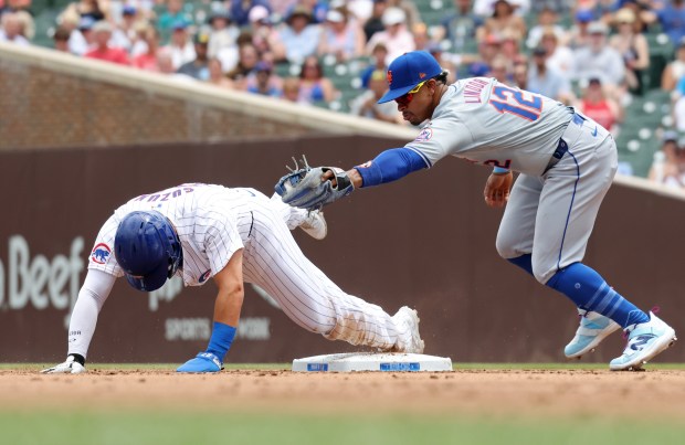 Cubs designated hitter Seiya Suzuki beats the tag from Mets shortstop Francisco Lindor (12) to steal second base in the first inning at Wrigley Field on June 22, 2024, in Chicago. (John J. Kim/Chicago Tribune)