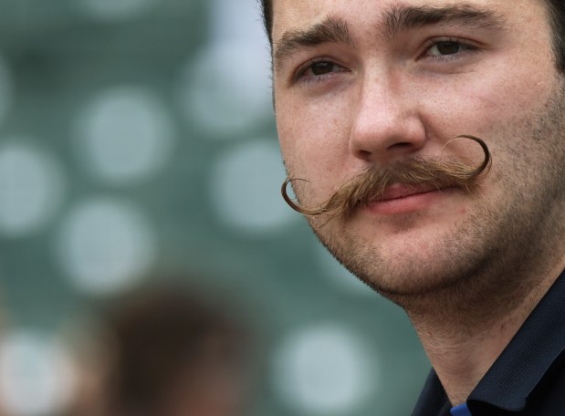 Grounds crew worker Zac Carson, sporting a mustache with curled tips, works before a game between the Cubs and Mets at Wrigley Field on June 22, 2024, in Chicago. (John J. Kim/Chicago Tribune)