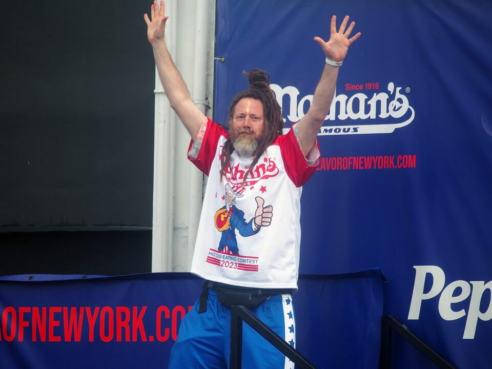 A man poses with his arms up in the air.