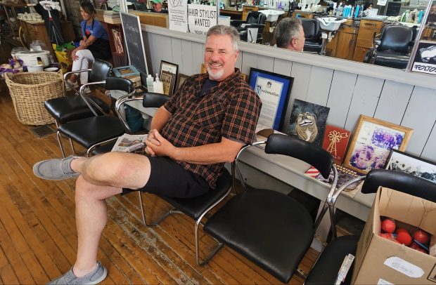 Steve Schoeling of North Aurora, a regular customer at Foltos Tonsorial Parlor in Batavia, relaxes on Friday at the 33rd annual Chop Around the Clock fundraising event at the barber shop. (David Sharos / For The Beacon-News)