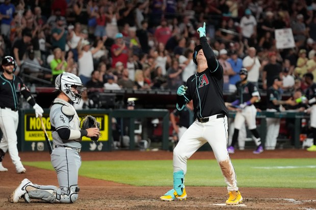 Arizona Diamondbacks designated hitter Joc Pederson points to the sky as he arrives at the plate after hitting a home run during the seventh inning on June 14, 2024, in Phoenix. At left is White Sox catcher Korey Lee. The Diamondbacks won 7-1. (Ross D. Franklin/AP)