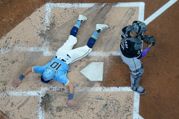 Milwaukee Brewers' Sal Frelick scores past Chicago White Sox catcher Martín Maldonado during the second inning of a baseball game Friday, May 31, 2024, in Milwaukee. (AP Photo/Morry Gash)