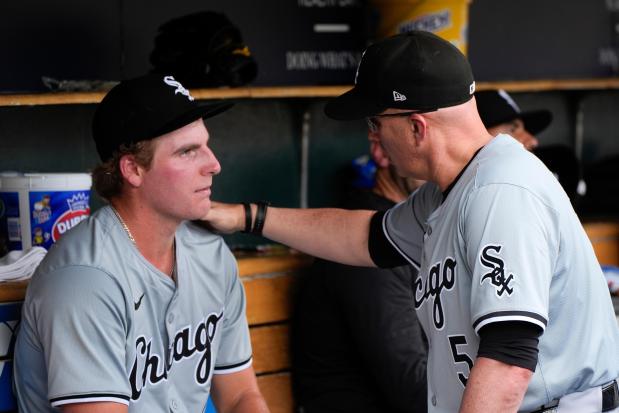 Chicago White Sox pitcher Jonathan Cannon, left, listens to manager Pedro Grifol (5) in the dugout in the second inning of a baseball game against the Detroit Tigers, Sunday, June 23, 2024, in Detroit. (AP Photo/Paul Sancya)