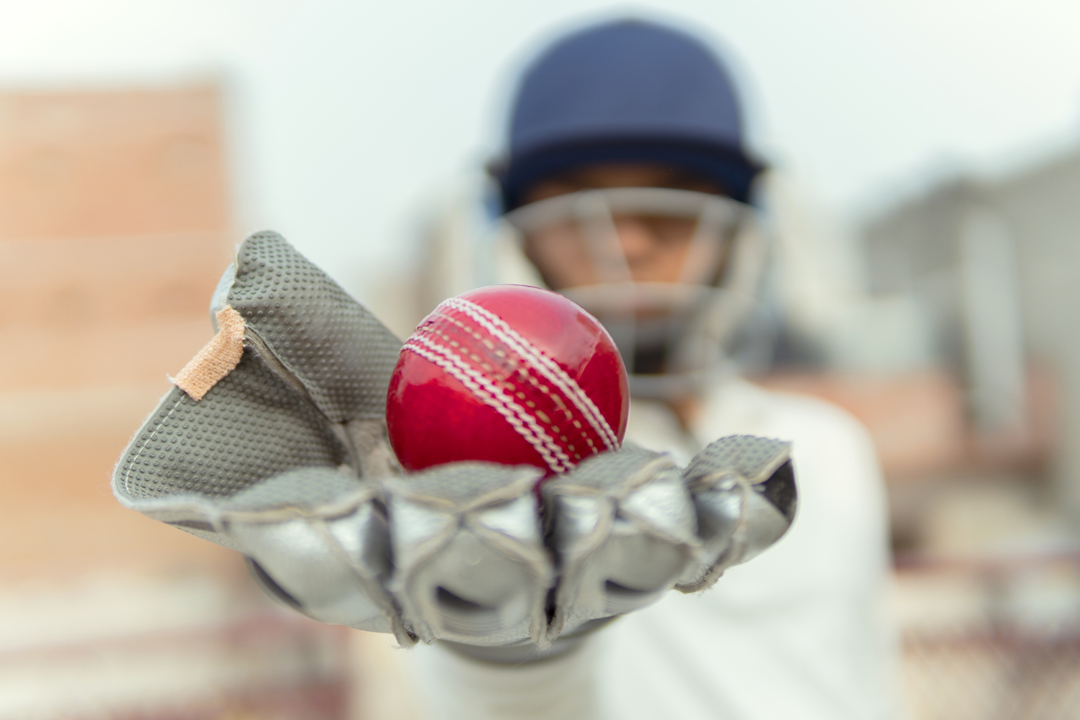 a teen player holds a cricket ball