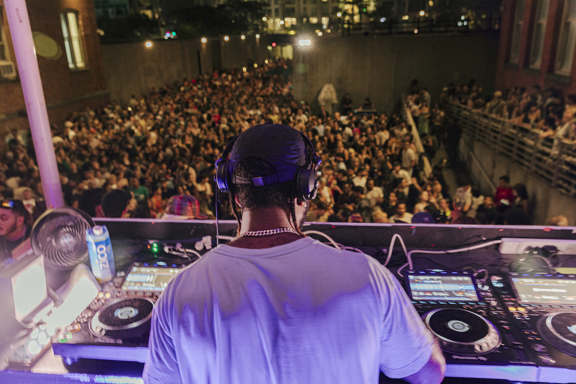 A DJ performs in front of a crowd.