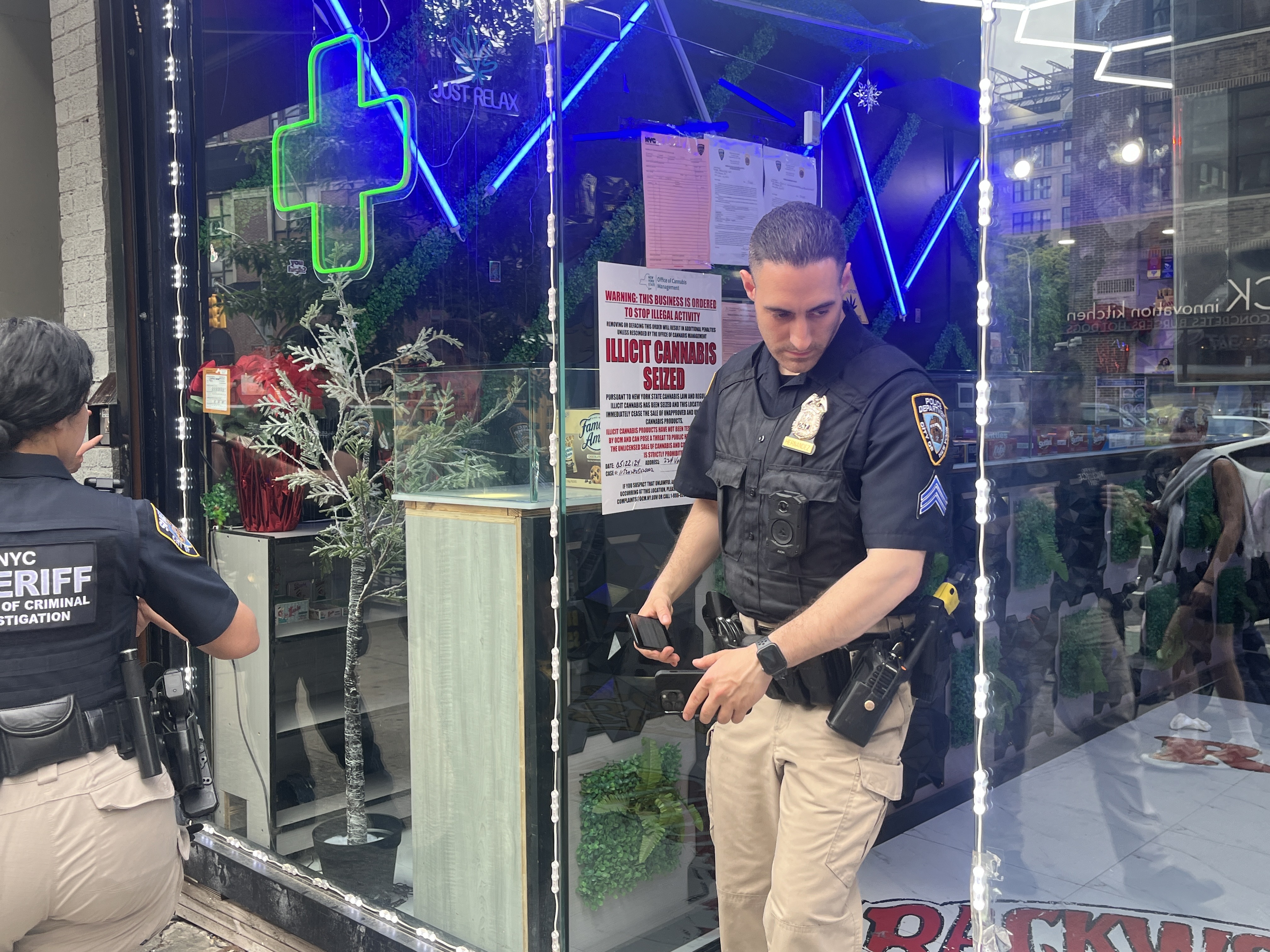 NYPD and city sheriff's officers raid a shop in SoHo as part of the city's ongoing crackdown on alleged unlicensed cannabis shops.