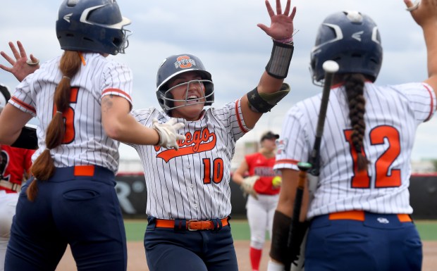 Oswego's Kiyah Chavez (10) is met at home by teammate Abby Schwab (6) Aubriella Garza (12). Oswego defeated Mundelein 12-7 in the Class 4A third-place game at Louisville Slugger Sports Complex in Peoria.(Rob Dicker / Daily Southtown)