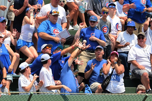 Fans catch a two-run home run hit by Pedro Pagés #43 of the St. Louis Cardinals (not pictured) during the second inning against the Chicago Cubs at Wrigley Field on June 16, 2024 in Chicago, Illinois. (Photo by Michael Reaves/Getty Images)
