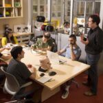 Hod Lipson speaks to students seated around a table working with robotics equipment in a Columbia Engineering lab.